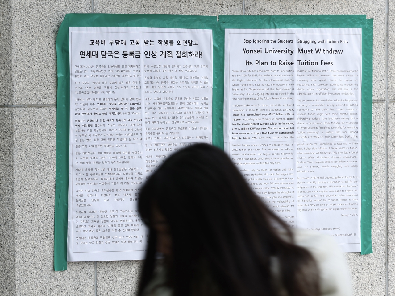 A student walks past protest posters at Yonsei University in Seoul urging the school administration to cancel its planned tuition increase in this photo taken on Jan. 20, 2025. Despite student opposition, the university approved its first undergraduate tuition hike in 15 years just four days later, raising fees by 4.98 percent. (Citizens' Alliance for Free and Standardized University Education)
