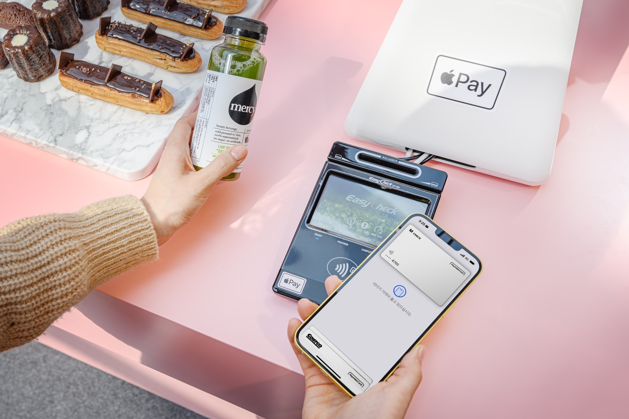 A customer uses Apple Pay with a Hyundai Card to purchase a drink at an NFC-enabled terminal in a Seoul cafe. Apple Pay officially launched in Korea on March 21, 2023, but limited merchant adoption and lack of transit support initially drew criticism. (Hyundai Card)