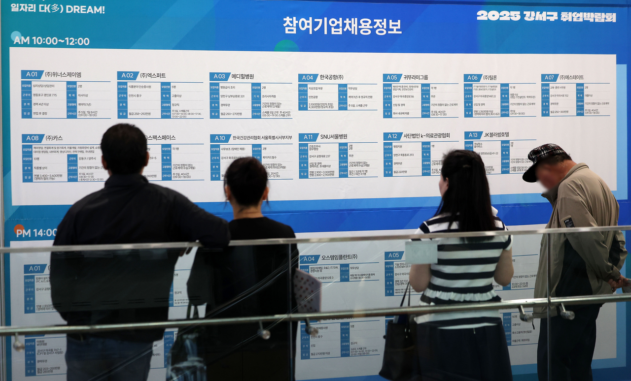 Job seekers are looking at a recruitment notice board at a job fair on June 26. (Newsis)