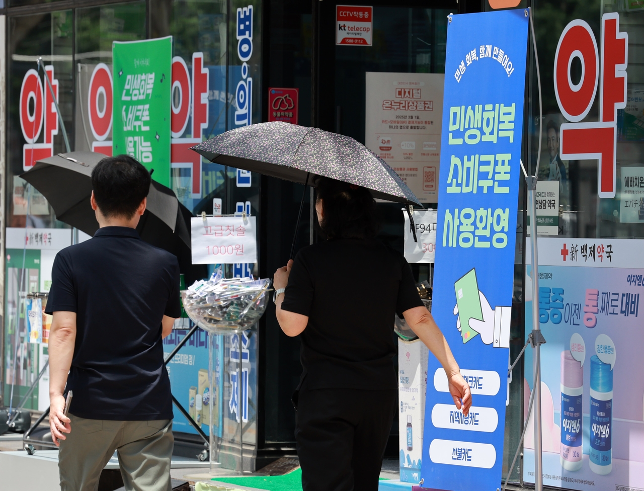 People walk past a pharmacy in central Seoul on July 22. (Newsis)