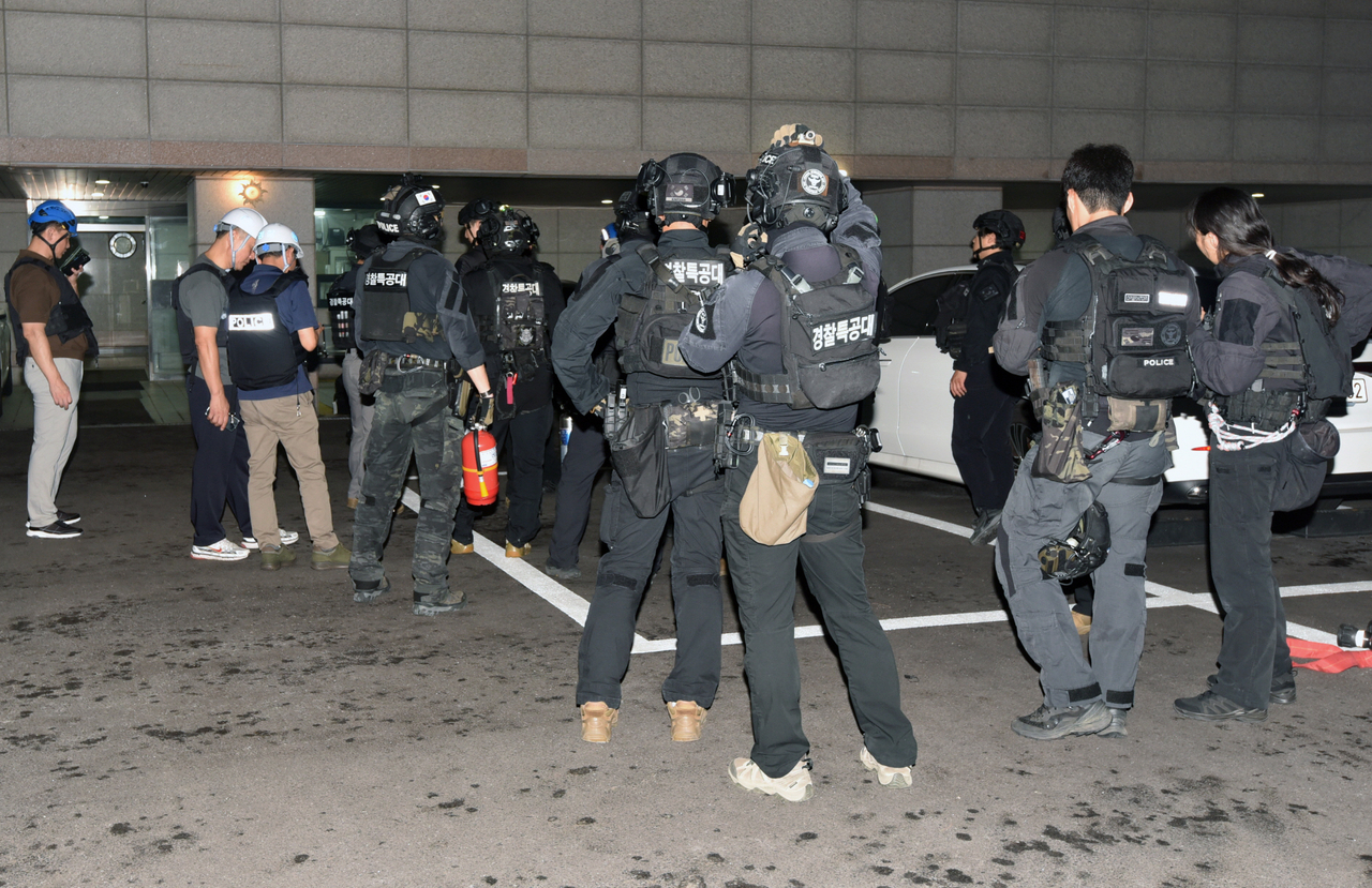 Police officials are seen at the Seoul residence of the suspect in the deadly shooting in Incheon, in this July 23 photo. (Yonhap)