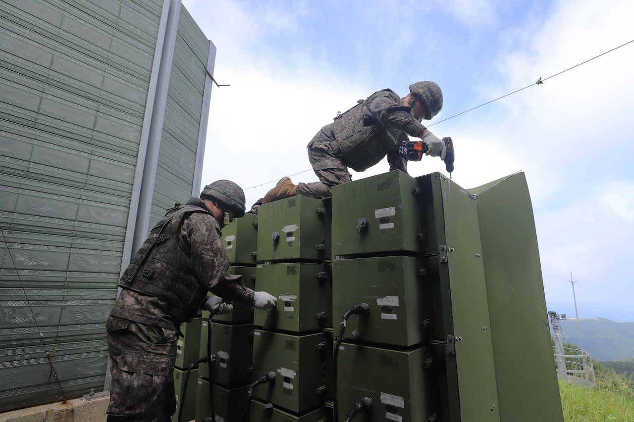 South Korean soldiers dismantle loudspeakers installed near the border with North Korea on Monday, in this photo provided by Seoul's Defense Ministry. (Yonhap)